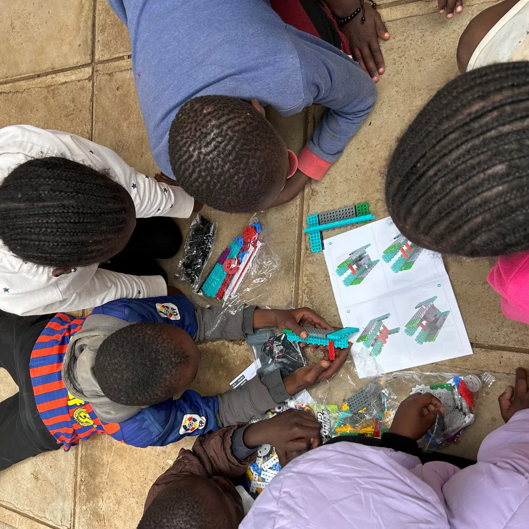 A group of kenyan kids on the floor doing unplugged coding activities