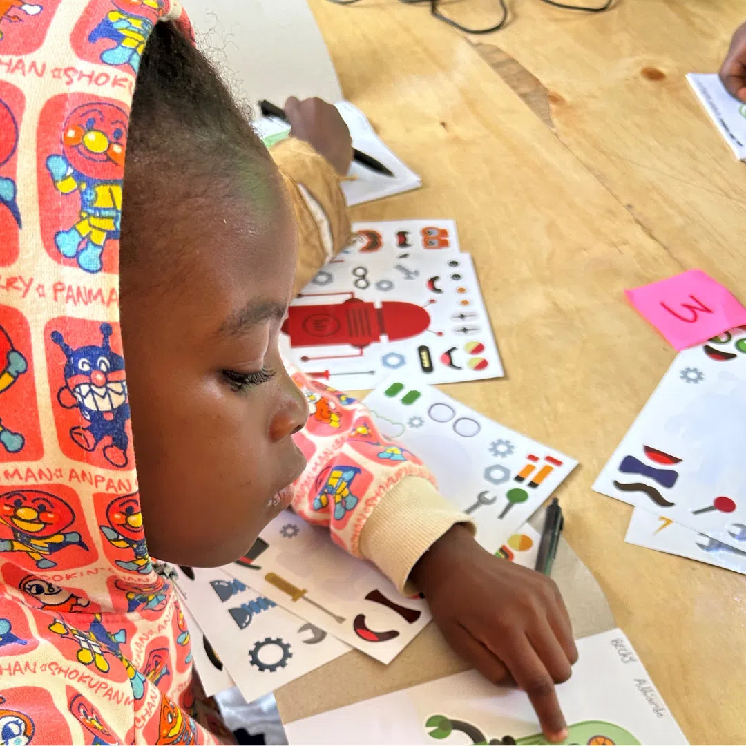 A kenyan girl doing an unplugged coding activity on paper